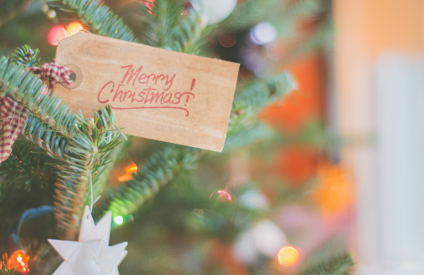 Label reading Merry Christmas sticking out of a Christmas tree